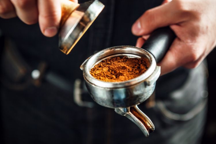 Barista holding portafilter and coffee tamper