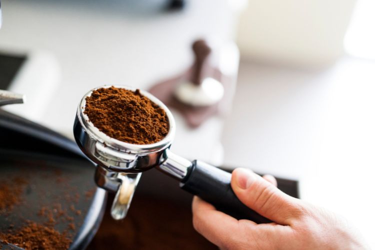 Barista holding portafiter with ground coffee inside