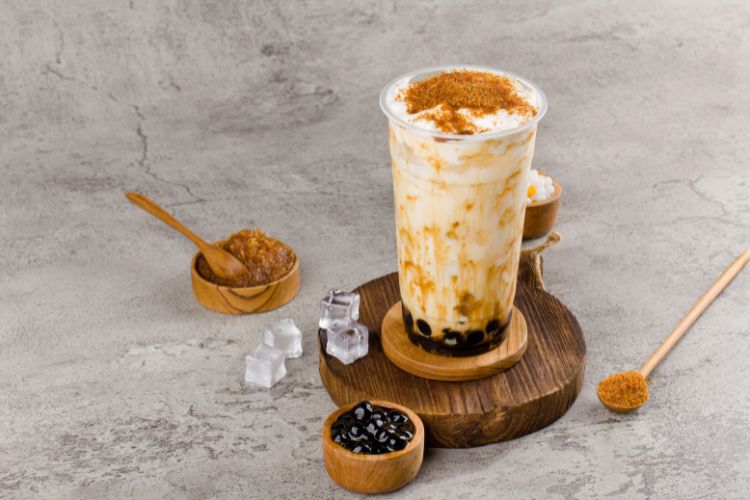 Boba tea on a counter with brown sugar sprinkled on top