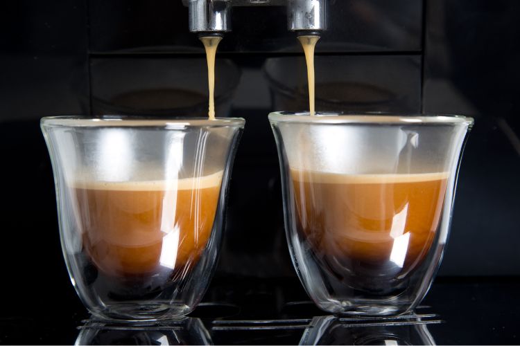 Golden espresso flowing into cups