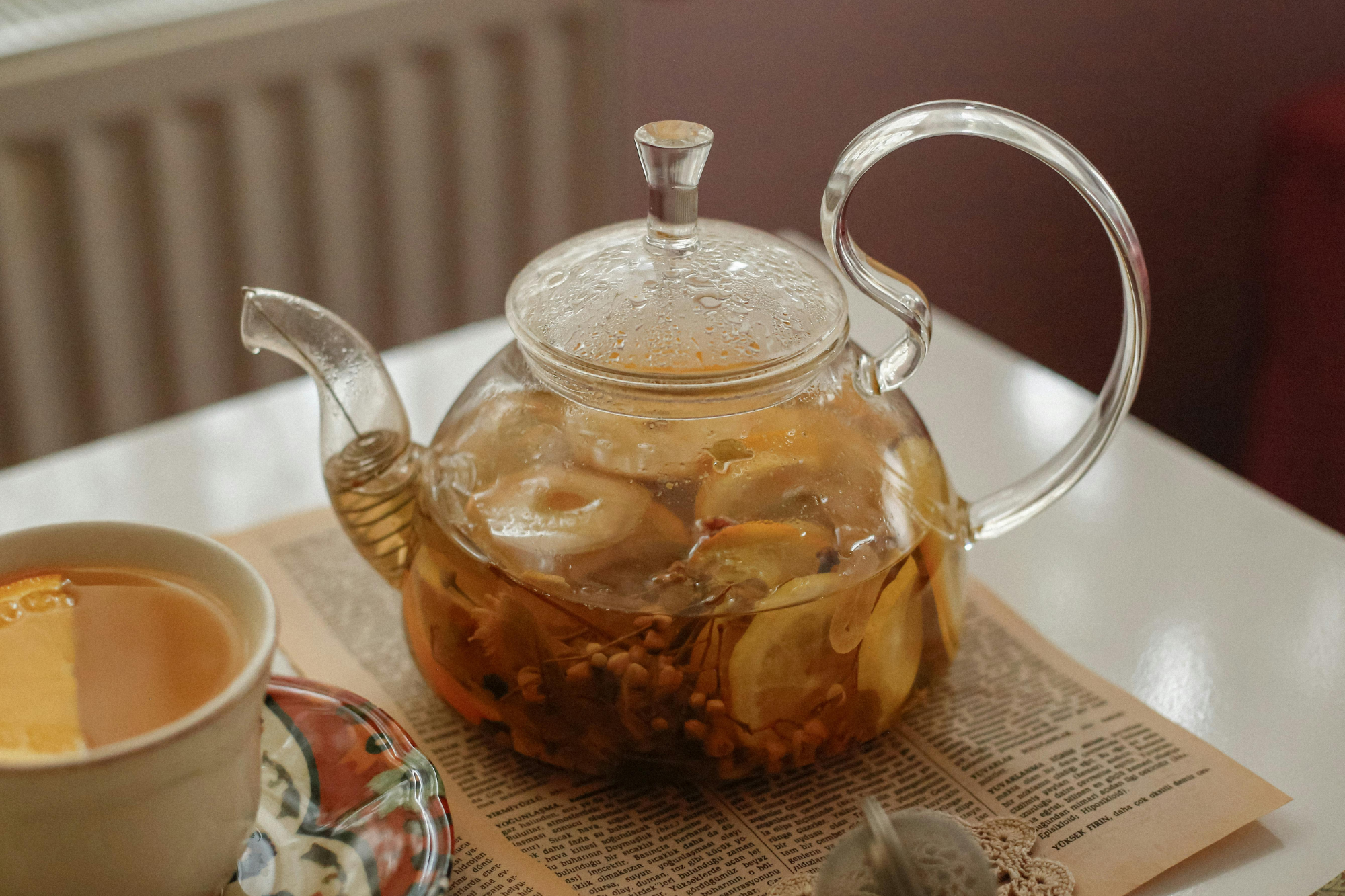 A frosty glass of iced tea, with lemon slices, placed on a classic diner or deli-style table.