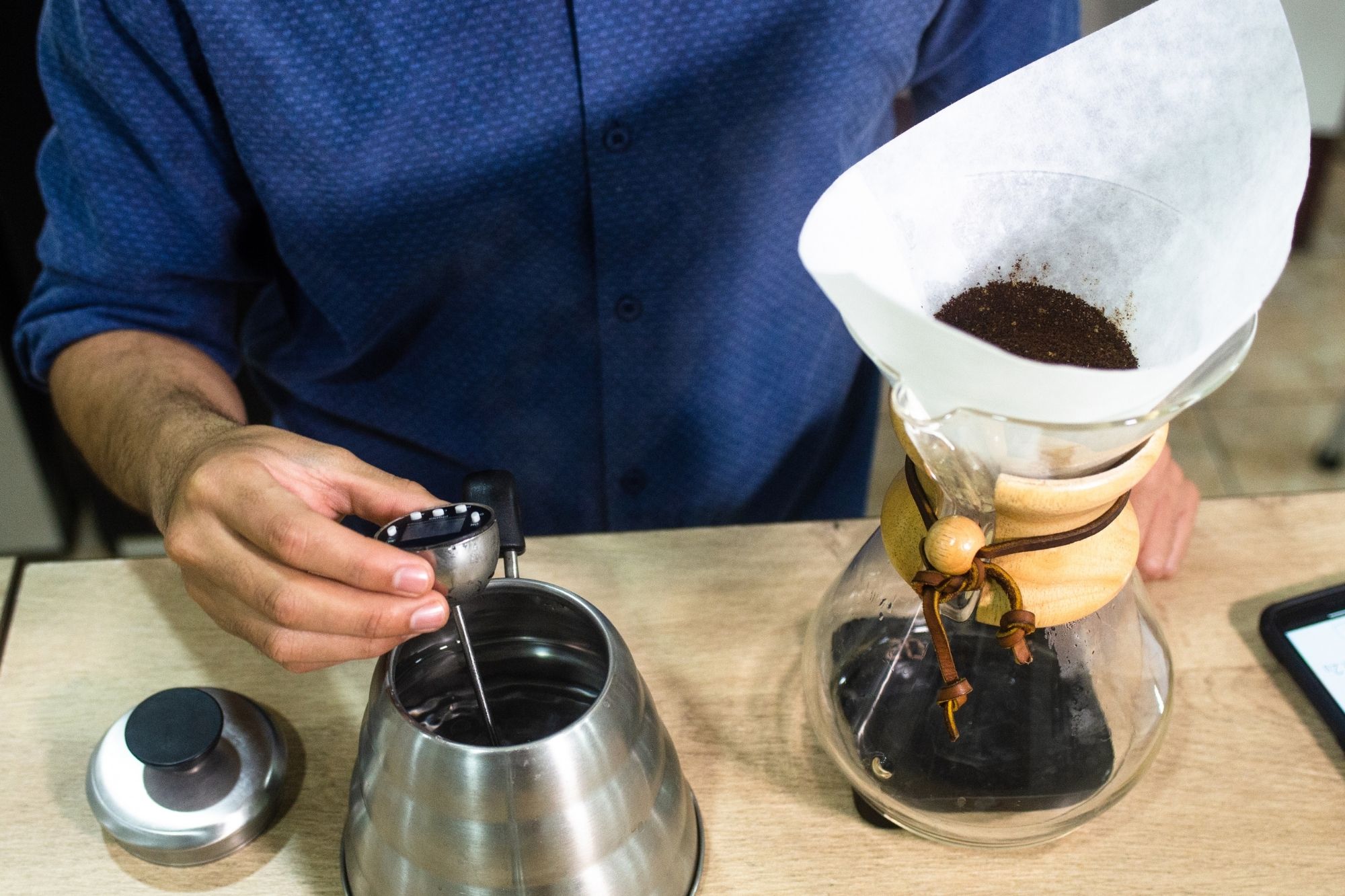A photo of coffee in a Chemex next to a Kettle.