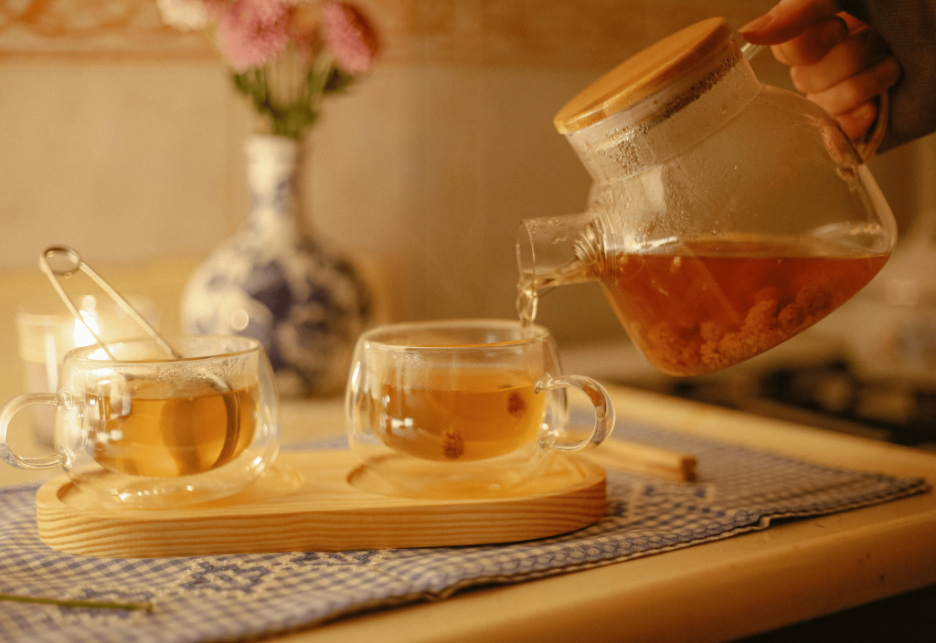 ginger cinnamon tea being poured from a pot into a teacup