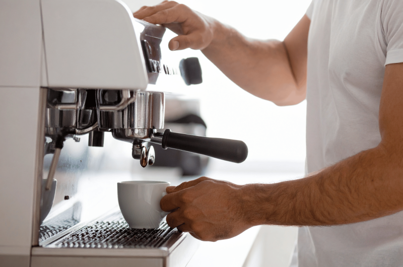 a man making coffee using an espresso machine