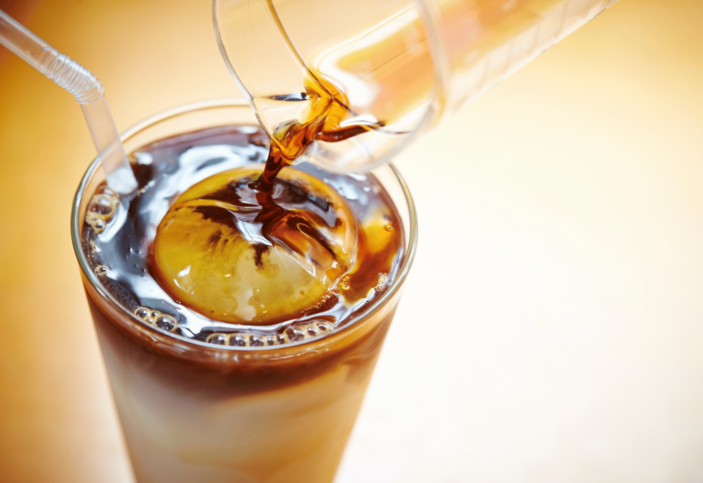 pouring brown butter toffee syrup on coffee